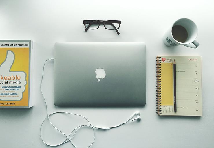 Notebook, myš, knihy, notes, dioptrické okuliare a káva na bielom stole.jpg